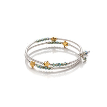 Load image into Gallery viewer, One size wrap around bangle style bracelet made from hand coiled silver filled tubes, with pretty gold plate stars, small faceted green coloured crystals & sterling silver beads. This bracelet has no clasp, it is flexible and simply wraps around the wrist and stays in place. It comes wrapped and presented in an eco friendly pretty linen gift pouch for safe keeping. Designed & Handmade in Dingle