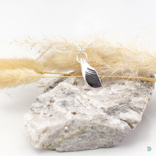 Load image into Gallery viewer, An unusual pendant made from a piece of salvaged sea shell from Castlegregory beach, and cast in sterling silver. Naturally tumbled by the ocean to create a beautifully smooth piece but still keeping its subtle markings and textures. A little piece of Kerrys Coast. This pendant is just shy of 3cm in size and sits on a chunky sterling silver chain and is 18inches in length. Designed and Handmade in Dingle