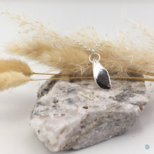 Load image into Gallery viewer, An unusual pendant made from a piece of salvaged sea shell from Castlegregory beach, and cast in sterling silver. Naturally tumbled by the ocean to create a beautifully smooth piece but still keeping its subtle markings and textures. A little piece of Kerrys Coast. This pendant is just shy of 3cm in size and sits on a chunky sterling silver chain and is 18inches in length. Hallmarked in Dublin Castle. Designed & Handmade Dingle