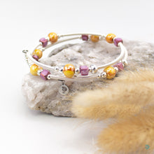 Load image into Gallery viewer, Easy to wear bracelet that simply wraps around the wrist and sits in place. No clasp needed. Hand wrapped silver filled tubes, with ceramic cubes in a mustard and purple colour mix with small sterling silver beads on each side and &quot;antique look&quot; silver plated sliders that move along the tubes. The diameter is approximately 6cm and they are flexible to fit most wrist sizes. They come beautifully presented in a velvet gift pouch for safe keeping. Designed and Handmade in Dingle
