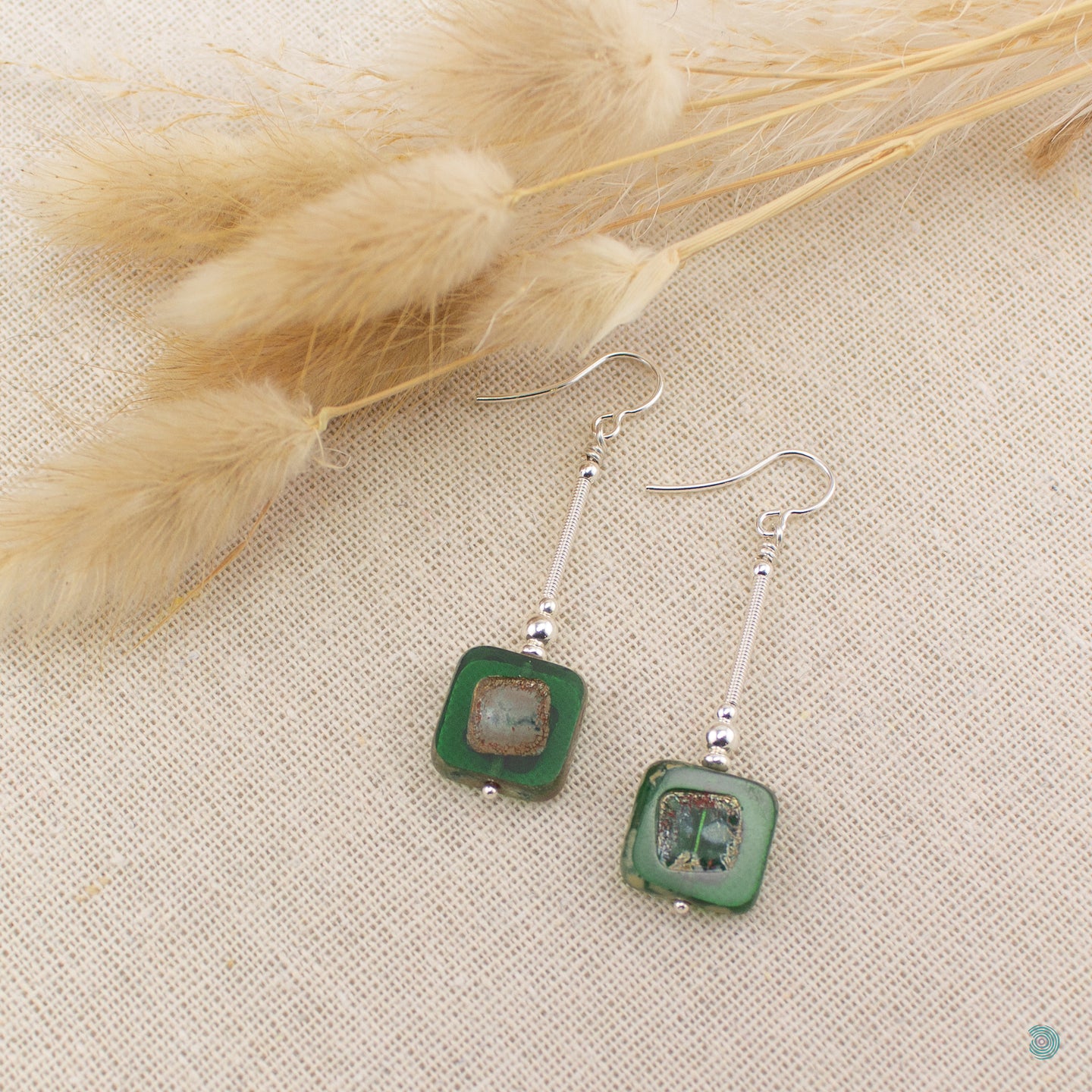 Hand wrapped silver filled drop earrings with pretty dark green Czech glass squares. These earrings sit on sterling silver ear wires and come with backs included. They are approximately 4cm in drop length from the base of the ear wires and are presented in a pretty gift pouch for safe keeping. Designed and handmade in Dingle