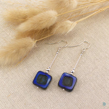 Load image into Gallery viewer, Hand wrapped silver filled drop earrings with a beautiful blue Czech glass squares. These earrings sit on sterling silver ear wires and come with backs included. They are approximately 4cm in drop length from the base of the ear wires and are presented in a pretty gift pouch for safe keeping. Designed and handmade in Dingle
