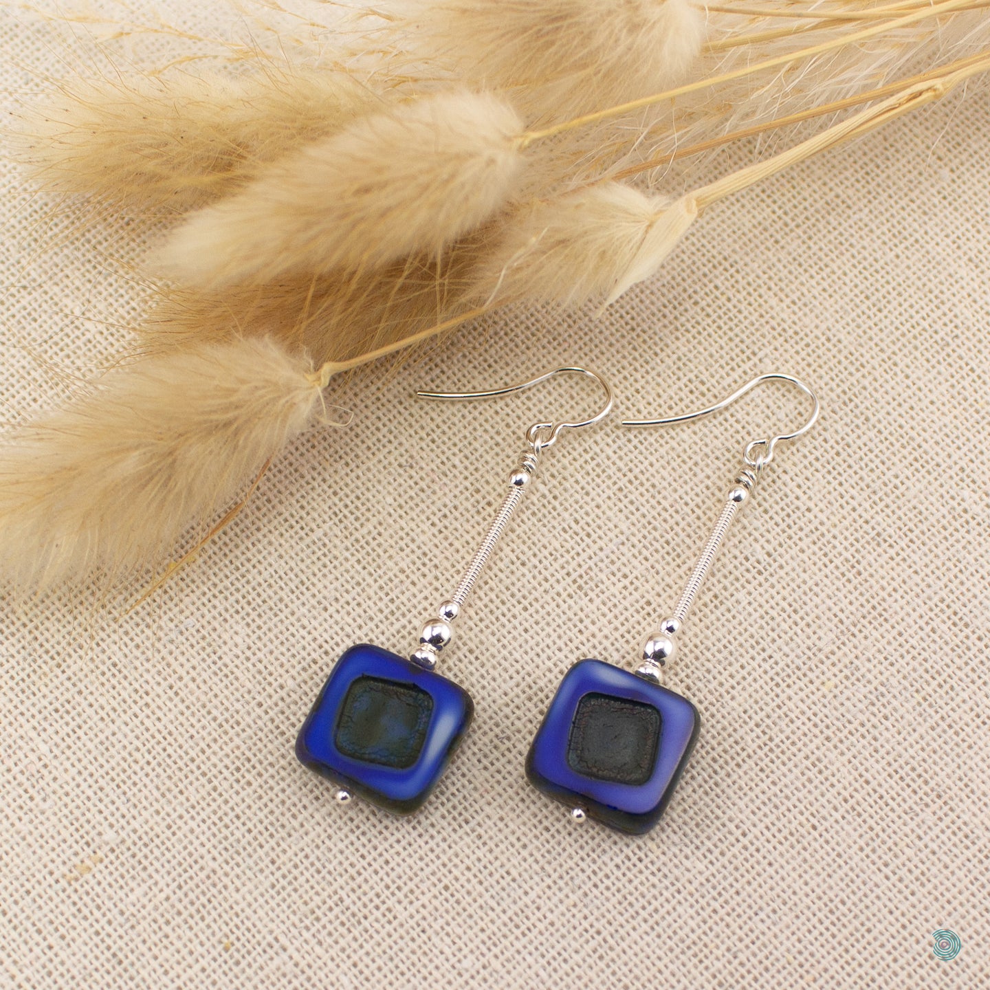Hand wrapped silver filled drop earrings with a beautiful blue Czech glass squares. These earrings sit on sterling silver ear wires and come with backs included. They are approximately 4cm in drop length from the base of the ear wires and are presented in a pretty gift pouch for safe keeping. Designed and handmade in Dingle