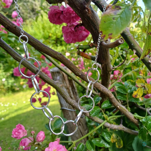 Sterling silver necklace, made up of 11 hammered silver hoops that make up the front of the necklace, that hand on a thick sterling silver chain.  This necklace is 18 inches on length and has a lobster clasp to close.  It comes presented in a pretty gift box making it perfect for gift giving or storing safely.  Designed and Handmade in Dingle.  Hallmarked in Dublin Castle
