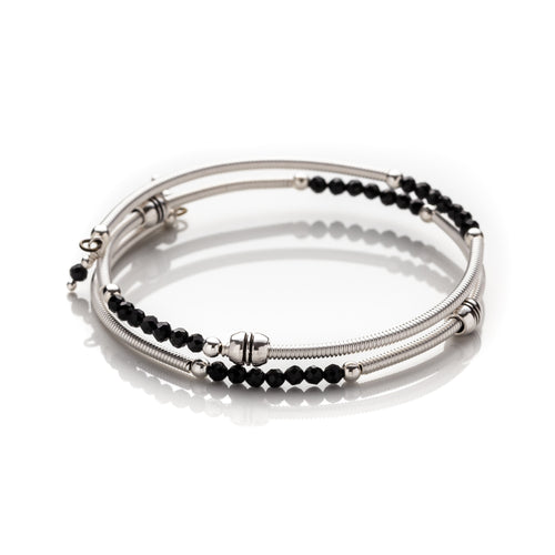 Bangle style wrap around bracelet made with hand coiled silver filled tubes with small faceted black crystals & sterling silver round beads.  This bracelet features silver plated barrel beads that slide freely along the tubes. This bracelet has no clasp, it is flexible and simply wraps around the wrist and stays in place. It comes beautifully presented in an eco friendly lien gift pouch for safe keeping.  Designed & Handmde in Dingle 