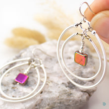 Load image into Gallery viewer, A real summer statement pair of earrings  Hand wrapped silver filled double hoops with red glass square centre beads that reflects light to change different colours.  These earrings are are lightweight and approximately 5cm in drop length from the base of sterling silver ear wires, they come with backs included.  Close up image of beads
