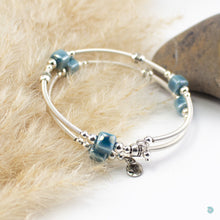Load image into Gallery viewer, Hand wrapped silver filled wrap around bracelet, blue ceramic cubes and silver bead detail. Approximate diameter is 6cm and is flexible to fit most wrist sizes. This bracelet has no clasp is simply wraps around the wrist and sits in place. Designed and Handmade in Dingle, Ireland. KellyMarie Jewellery Design
