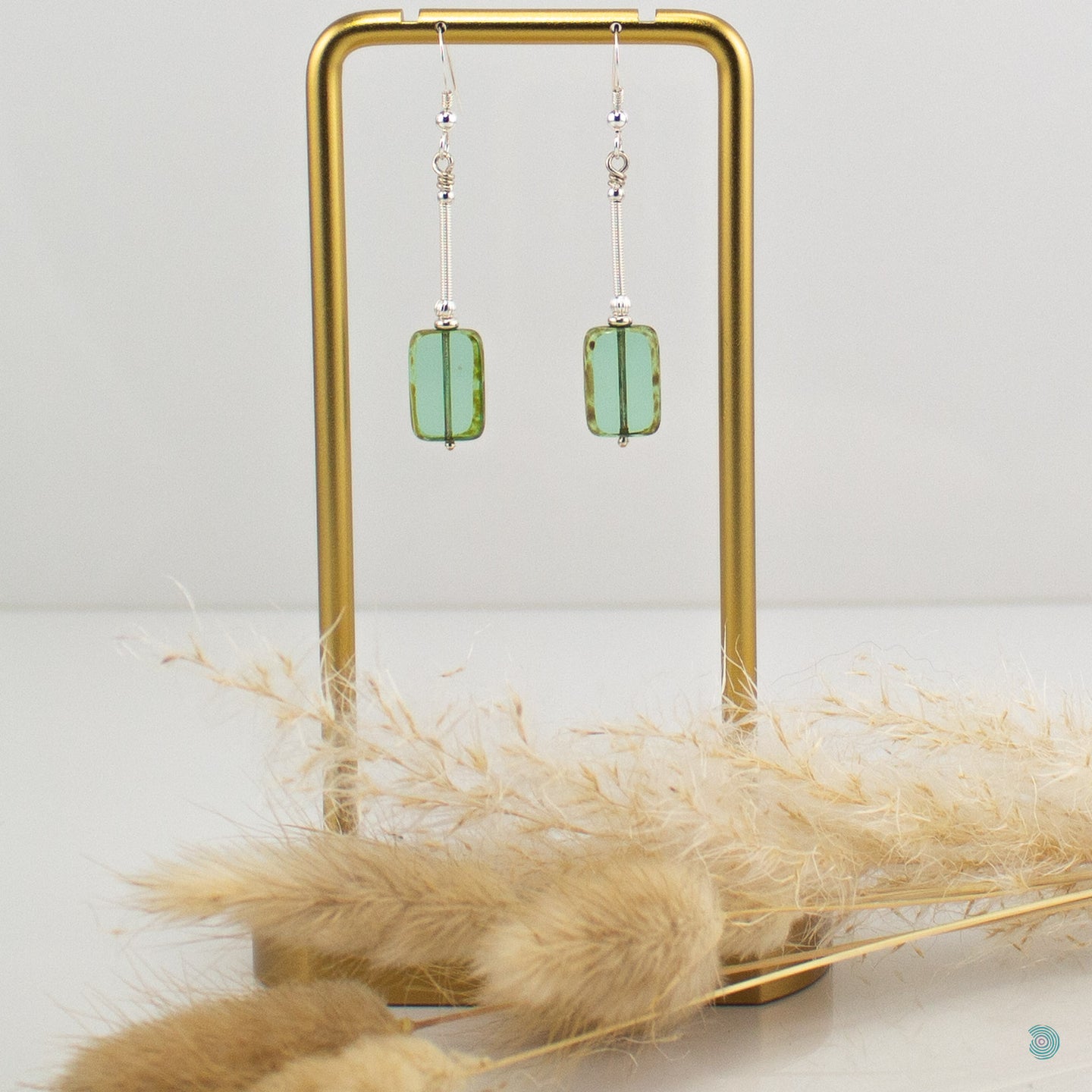 Hand wrapped silver filled drop earrings with a beautiful green Czech glass rectangular bead. These earrings sit on sterling silver ear wires and come with backs included. They are approximately 4cm in drop length from the base of the ear wires and are presented in a pretty gift pouch for safe keeping. Designed and handmade in Dingle