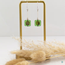 Load image into Gallery viewer, Hand wrapped silver filled drop earrings with pretty light green Czech glass squares. These earrings sit on sterling silver ear wires and come with backs included. They are approximately 4cm in drop length from the base of the ear wires and are presented in a pretty gift pouch for safe keeping. Designed and handmade in Dingle
