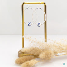 Load image into Gallery viewer, Hand wrapped silver filled statement hoop earrings with a pretty blue and white floral ceramic bead threaded onto the hoop.  These earrings are lightweight ann 4.5cm in drop length from the base of the ear wires.  They come with backs included and are presented in a pretty gift pouch for safe keeping or making them perfect for gift giving
