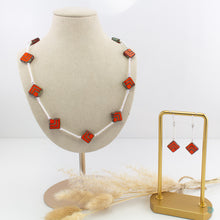 Load image into Gallery viewer, Hand wrapped silver filled tubes with vibrant orange Czech glass diamond shaped beads and sterling silver small bead detail. This necklace is 18 inches in length with a 2 inch extension chain for adjustment. It comes beautifully presented in a branded gift box for safe keeping or making it perfect for gift giving Designed and Handmade in Dingle
