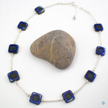 Load image into Gallery viewer, Hand wrapped silver filled tubes, with vibrant blue coloured Czech glass squares and sterling silver beads.  This necklace is 18 inches in length and has a 2 inch extension chain for adjustment.  It comes in a branded gift box for safe keeping or making it perfect for gift giving.  Designed and Handmade in Dingle 
