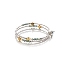 Load image into Gallery viewer, One size wrap around bangle style bracelet made from hand coiled silver filled tubes, with pretty gold plate stars, small faceted green coloured crystals &amp; sterling silver beads.  This bracelet has no clasp, it is flexible and simply wraps around the wrist and stays in place.  It comes wrapped and presented in an eco friendly pretty linen gift pouch for safe keeping. Designed &amp; Handmade in Dingle
