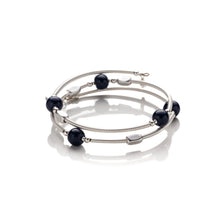 Load image into Gallery viewer, One size bangle style wrap around bracelet made from hand coiled silver filled tubes with navy blue round glass beads &amp; sterling silver beads. This piece has silver plated rectangular beads that slide freely along the tubes. It has no clasp, it is flexible and simply wraps around the wrist and stays in place. It comes beautifully presented in an eco friendly linen gift pouch. Designed &amp; Handmade in Dingle
